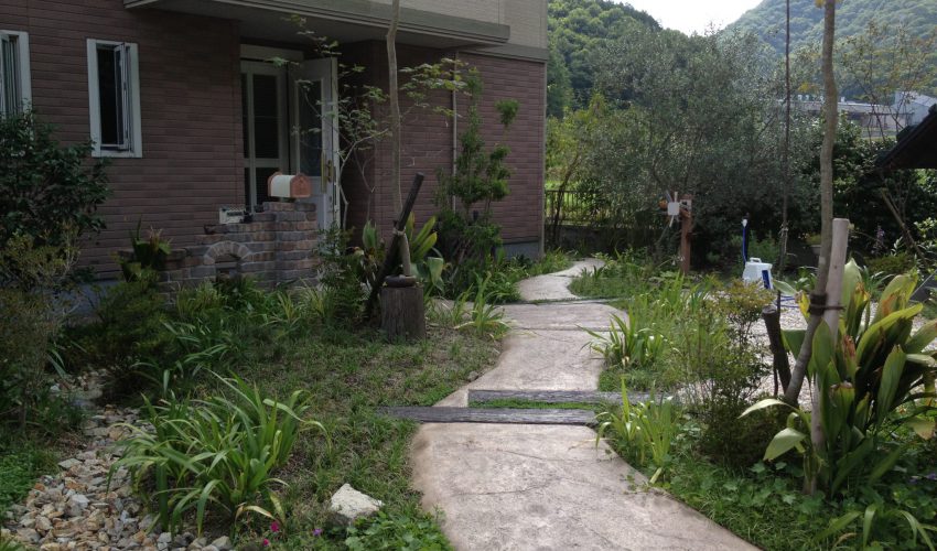 スタンプコンクリートと植物で造る 遊歩道のようなアプローチ